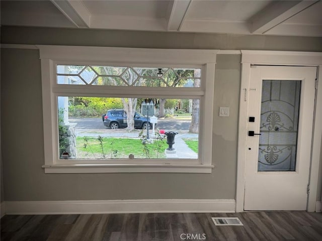 interior details with beam ceiling, visible vents, baseboards, and wood finished floors