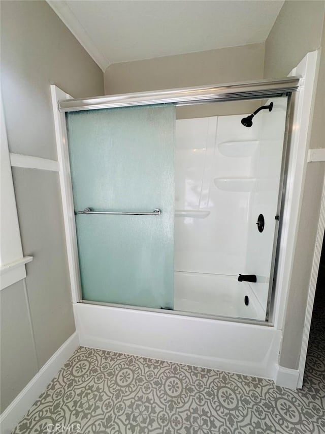 bathroom featuring tile patterned floors, crown molding, baseboards, and enclosed tub / shower combo