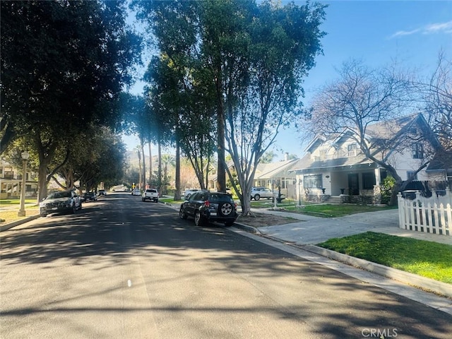 view of street with sidewalks, curbs, and a residential view