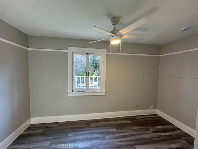 empty room featuring baseboards, dark wood finished floors, and a ceiling fan