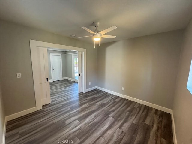 unfurnished room featuring dark wood-type flooring, baseboards, and ceiling fan