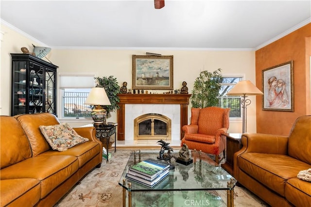 living area featuring plenty of natural light, a tile fireplace, and crown molding