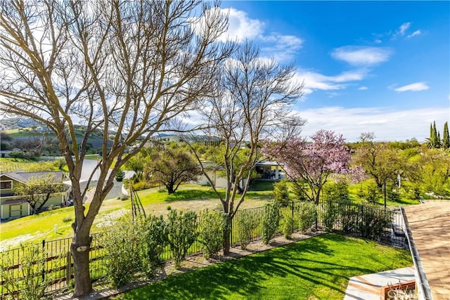 view of community featuring a yard and fence