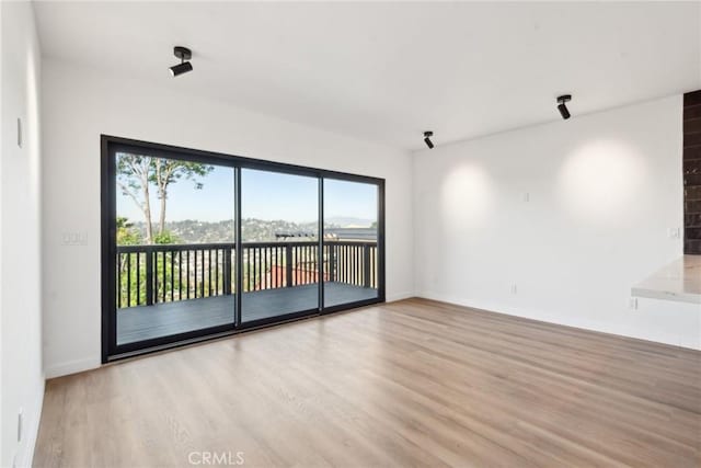 empty room featuring baseboards and wood finished floors