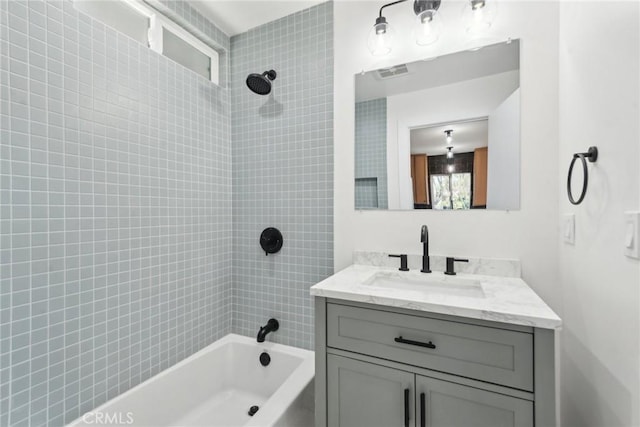 full bath featuring visible vents, vanity, and shower / bathtub combination