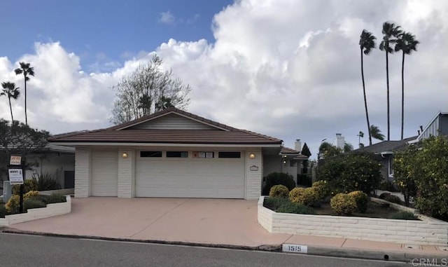 ranch-style home with a garage, driveway, and a tiled roof