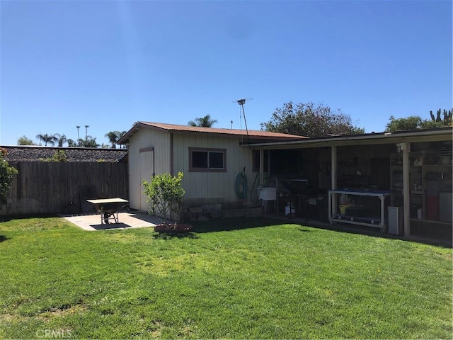 back of property with a patio, fence, and a lawn