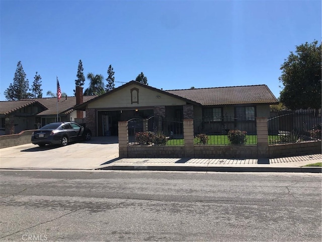 single story home featuring a fenced front yard, a tiled roof, concrete driveway, and a garage