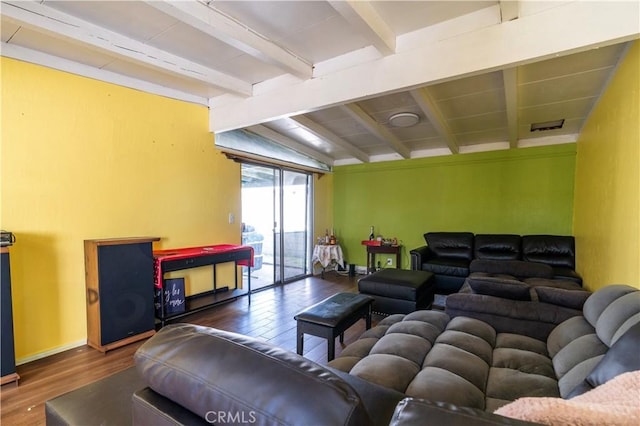 living area with lofted ceiling with beams, wood finished floors, baseboards, and visible vents