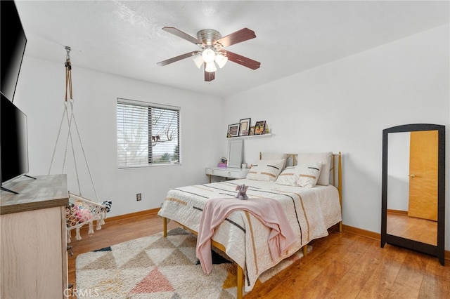 bedroom with baseboards, a ceiling fan, and hardwood / wood-style flooring