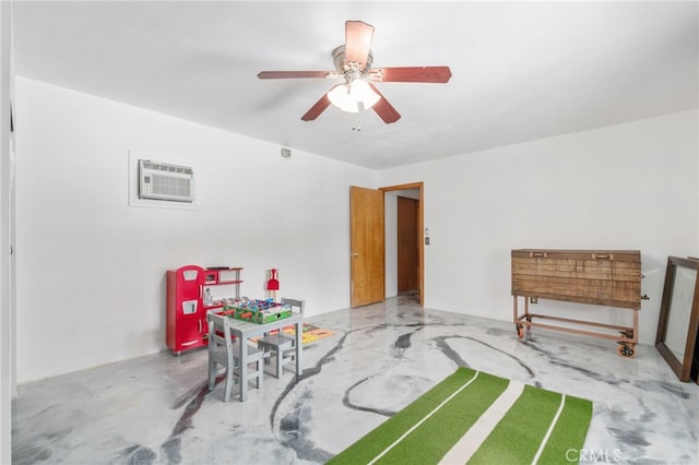 recreation room with an AC wall unit, concrete floors, and a ceiling fan