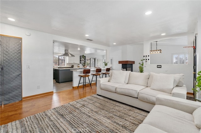 living area featuring recessed lighting, light wood-style flooring, baseboards, and visible vents