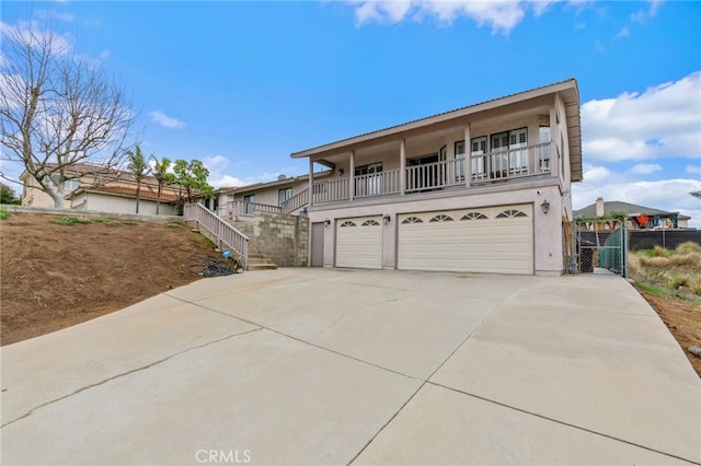 view of front property featuring stairs, concrete driveway, a garage, and stucco siding