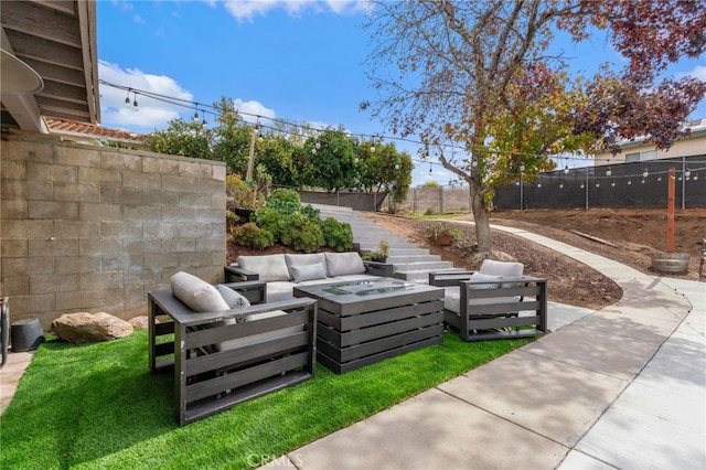 view of patio featuring an outdoor living space with a fire pit and fence