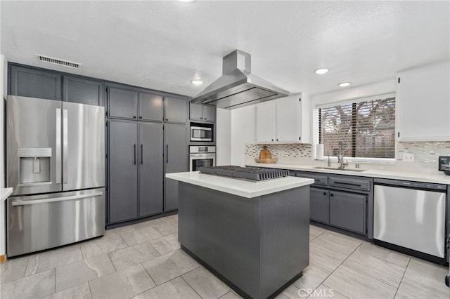 kitchen with a sink, light countertops, appliances with stainless steel finishes, and island range hood