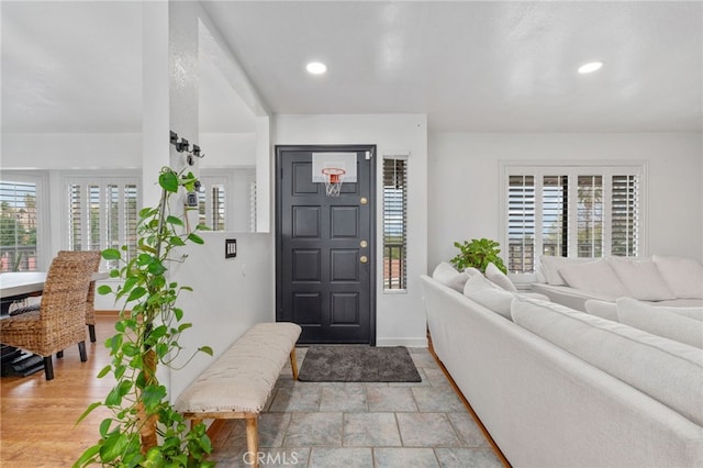 entryway featuring recessed lighting, stone finish flooring, and baseboards