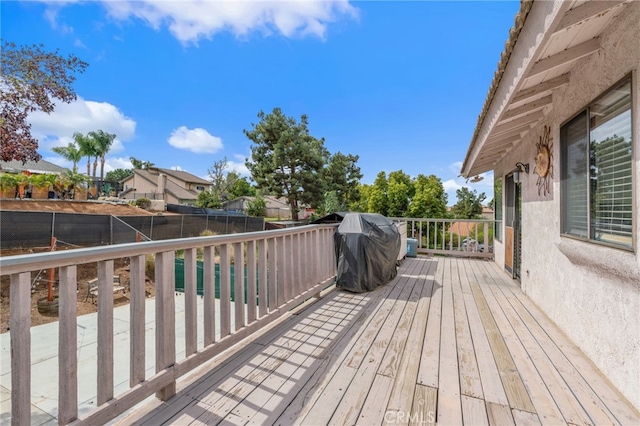 deck with area for grilling and a fenced backyard