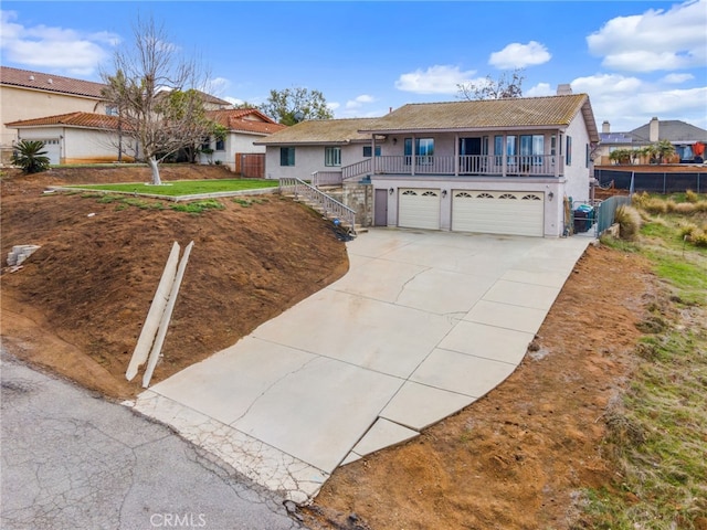 view of front of home with stairway, a tile roof, stucco siding, a garage, and driveway