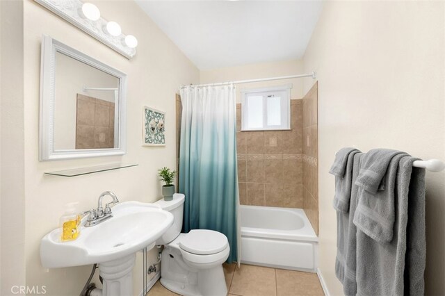 bathroom with a sink, toilet, shower / bath combination with curtain, and tile patterned flooring