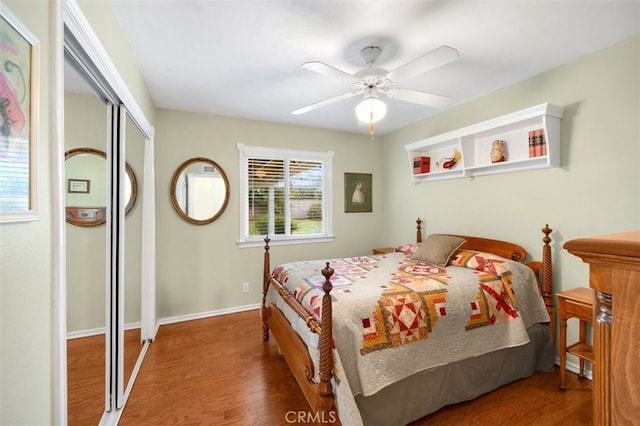 bedroom featuring ceiling fan, a closet, baseboards, and wood finished floors