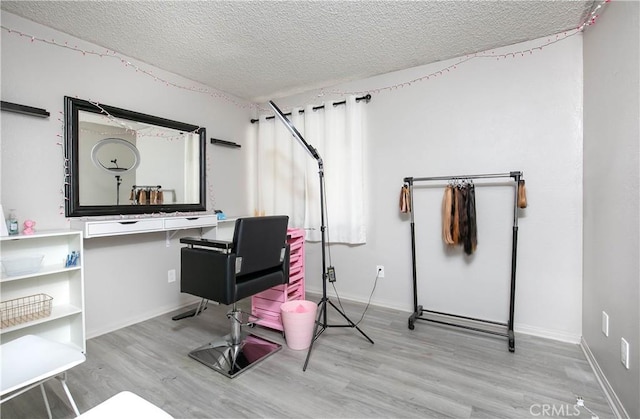 home office featuring a textured ceiling, baseboards, and wood finished floors