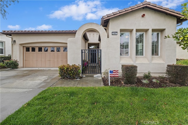 mediterranean / spanish-style house with a tiled roof, driveway, a garage, a front yard, and stucco siding