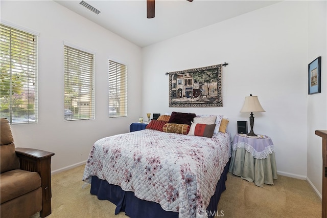 carpeted bedroom with ceiling fan, visible vents, baseboards, and multiple windows