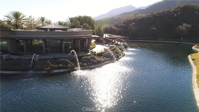 view of swimming pool with a patio and a water and mountain view