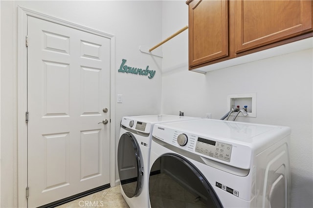 laundry area with washer and clothes dryer, light tile patterned floors, and cabinet space