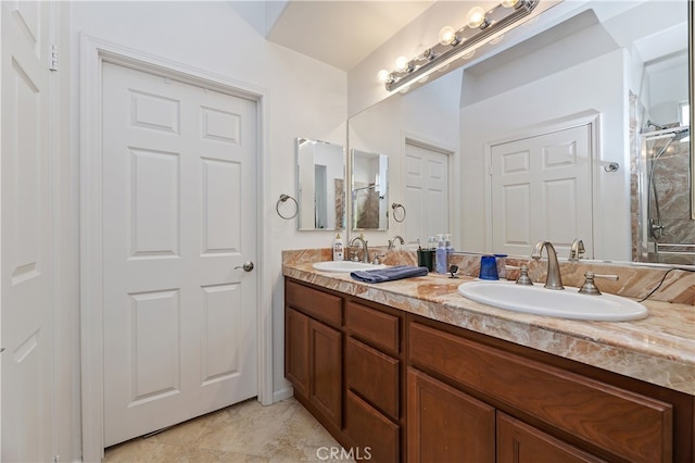 bathroom with an enclosed shower, a sink, and double vanity