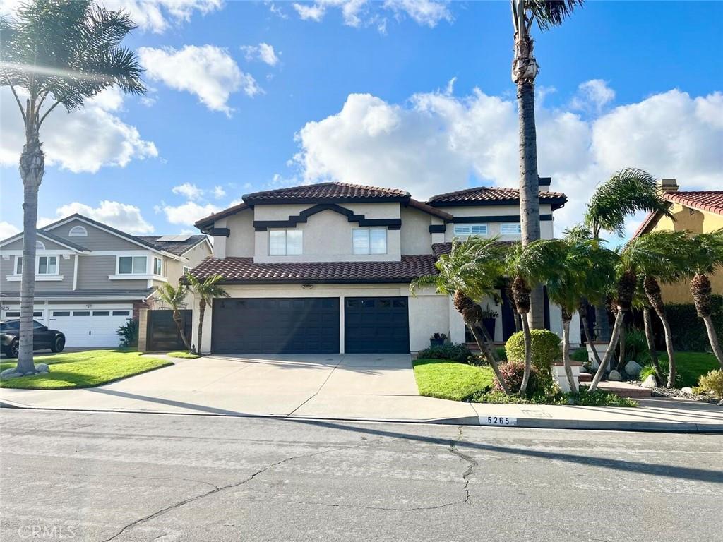 mediterranean / spanish-style home featuring stucco siding, an attached garage, a tile roof, and concrete driveway