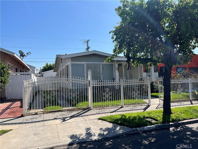 view of front of home with a fenced front yard and a gate