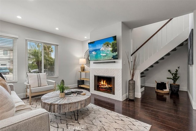 living area featuring recessed lighting, a tile fireplace, baseboards, and wood finished floors