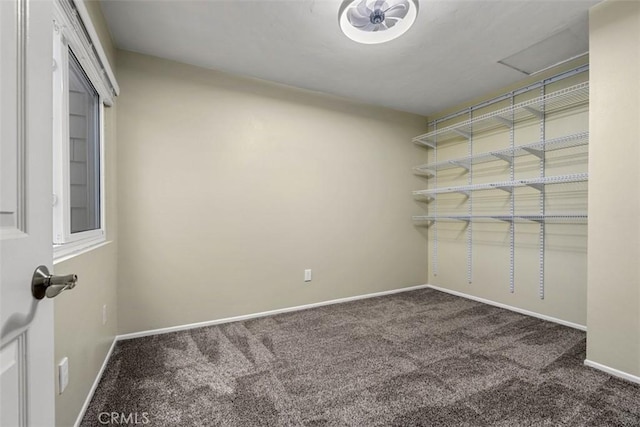 carpeted empty room featuring baseboards