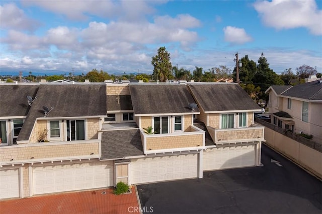 multi unit property featuring a garage and aphalt driveway