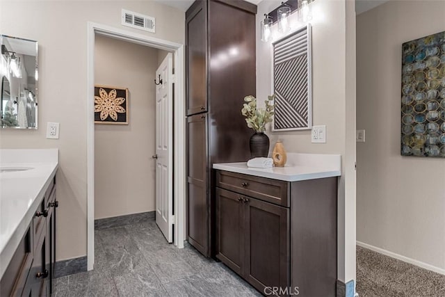 bathroom featuring visible vents, baseboards, and vanity