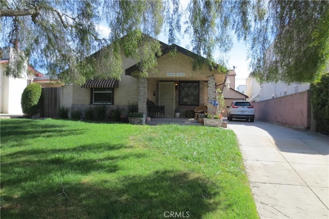 view of front of property with stone siding, stucco siding, concrete driveway, and a front lawn