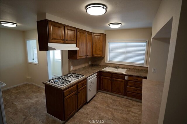 kitchen featuring under cabinet range hood, white appliances, a healthy amount of sunlight, and a sink