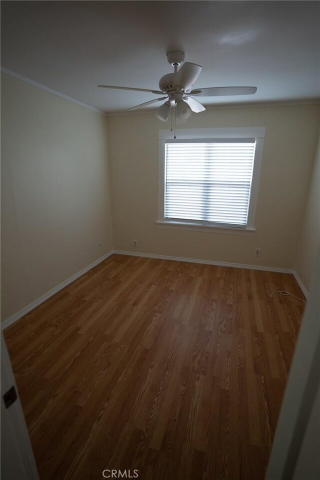 unfurnished room with ceiling fan, baseboards, light wood-type flooring, and ornamental molding