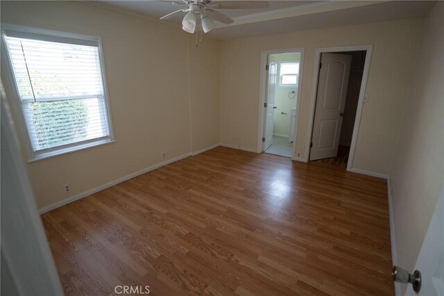 spare room featuring light wood-style flooring, ornamental molding, baseboards, and ceiling fan