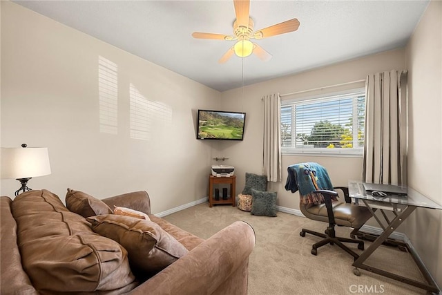 carpeted office space with a ceiling fan and baseboards