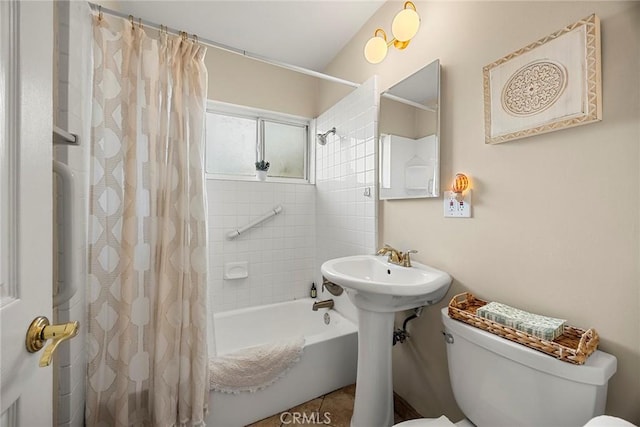 bathroom featuring shower / bath combination with curtain, toilet, and a sink