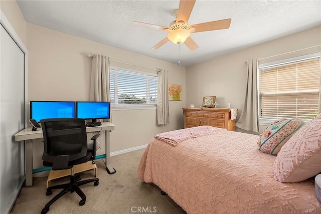 bedroom with a ceiling fan, a textured ceiling, a closet, carpet floors, and baseboards