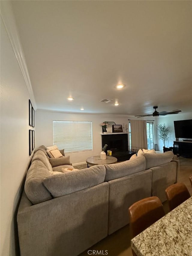 living room featuring recessed lighting, visible vents, and ornamental molding