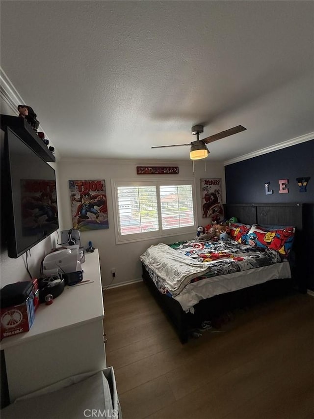 bedroom featuring a ceiling fan, crown molding, wood finished floors, and a textured ceiling