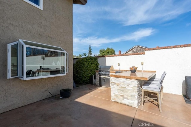 view of patio with outdoor wet bar and area for grilling