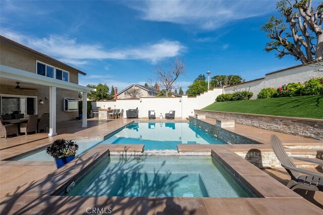 view of swimming pool with a patio, a fenced backyard, and a pool with connected hot tub