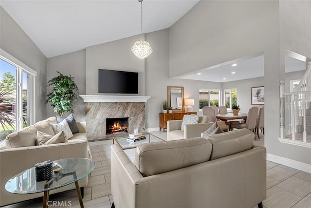 living room featuring recessed lighting, a premium fireplace, baseboards, and high vaulted ceiling