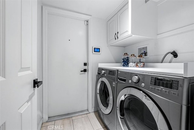 laundry area featuring washing machine and dryer, cabinet space, and wood tiled floor