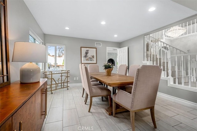 dining room featuring visible vents, baseboards, wood tiled floor, recessed lighting, and stairs